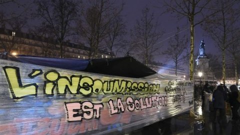 A banner reads, "disobedience is the solution" is displayed as people join the "Nuit Debout" or "Standing night" movement at the Place de la Republique in Paris on April 2, 2016. 
A few hundred people rallied to demand the halt of "home evictions" which can begin the day after the end of the French winter break, after which tenants can be evicted from their homes. They also gathered to show their opposition to the labour reform law in the wake of the nationwide demonstration which took place on March 31. / AFP PHOTO / DOMINIQUE FAGET
